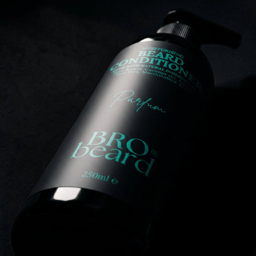 A 250ml pump bottle of BRO beard conditioner, Parfum variant, featuring a matte black label with teal text and a black pump dispenser, set against a dark, moody background.